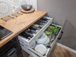 a kitchen drawer filled with dishes and utensils at Apartament Wiślańskie Skije in Wisła