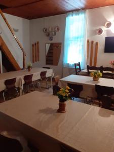 uma sala com mesas e cadeiras com flores em Cabana Valea Stanciului em Rachitele