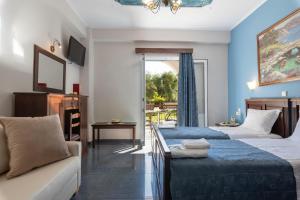 ein Hotelzimmer mit zwei Betten und einer Couch in der Unterkunft Byzantio in Parga + 45 Fotos