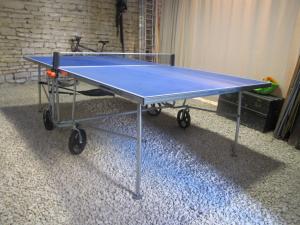 una mesa de ping pong azul en una habitación en Les moinillons - Piscine à 28 degrés en service toute l'année en Ancy-le-Franc