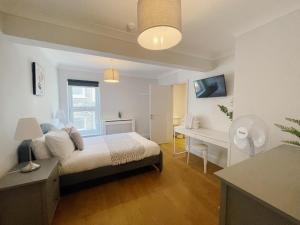 1 dormitorio con cama y escritorio. en Stunning 8-Bed House with Sea & Beach Views, en Great Yarmouth