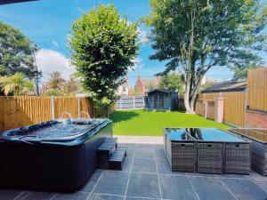 a backyard with a jacuzzi and two tables at Stunning 8-Bed House with Sea & Beach Views in Great Yarmouth