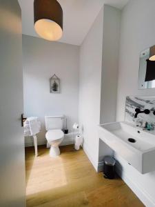 y baño con aseo blanco y lavamanos. en Stunning 8-Bed House with Sea & Beach Views, en Great Yarmouth