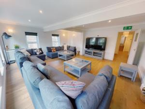 sala de estar con sofá azul y TV en Stunning 8-Bed House with Sea & Beach Views, en Great Yarmouth