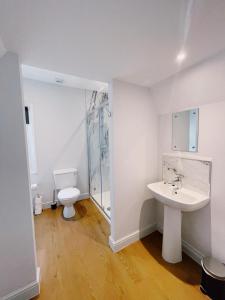 Baño blanco con lavabo y aseo en Stunning 8-Bed House with Sea & Beach Views, en Great Yarmouth