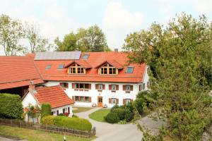 una grande casa bianca con tetti rossi di Michlhof a Oberostendorf