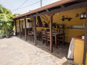 ロス・レアレホスにあるCasa Rural La Gañaníaの屋根の下にテーブルと椅子付きのパティオ