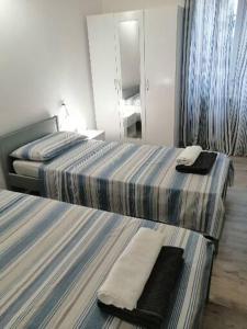 um quarto de hotel com duas camas e um espelho em Albergo blue fish em Albisola Superiore