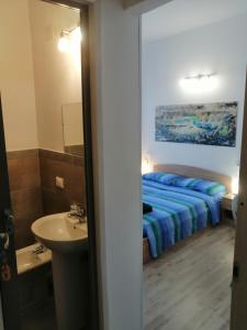 uma casa de banho com uma cama e um lavatório num quarto em Albergo blue fish em Albisola Superiore