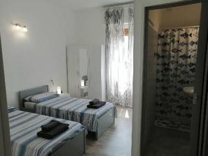 a hotel room with two beds and a shower at Albergo blue fish in Albisola Superiore