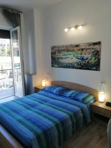 um quarto com uma cama e um quadro na parede em Albergo blue fish em Albisola Superiore