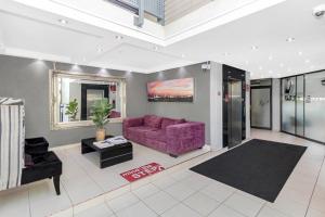 sala de estar con sofá púrpura y mesa en West Point Properties, en Johannesburgo