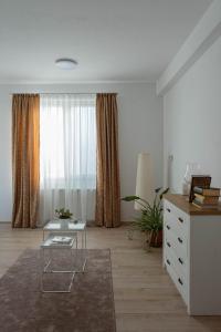 a living room with a table and a window at Solomon Apartments Ap 4 in Sângeorgiu de Mureș