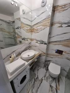 CedzynaにあるApartament Business & Living No 91 Nad Zalewem w Cedzynie, hala garażowaの大理石のバスルーム(洗面台、トイレ付)
