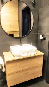a bathroom with a sink and a mirror at Drzewna Apartamenty -Augustowska in Zielona Góra