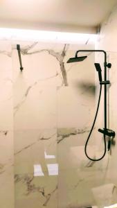 a shower in a room with a marble wall at Drzewna Apartamenty -Augustowska in Zielona Góra