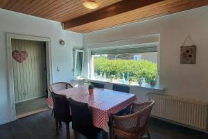 uma sala de jantar com uma mesa e cadeiras e uma janela em Monteurzimmer Ausma Wymeer Bunde - FeWo Vakantiehuis Heerenland em Bunde