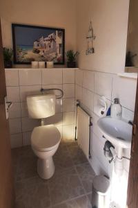 uma casa de banho com um WC e um lavatório em Monteurzimmer Ausma Wymeer Bunde - FeWo Vakantiehuis Heerenland em Bunde