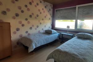 um quarto com 2 camas e uma janela em Monteurzimmer Ausma Wymeer Bunde - FeWo Vakantiehuis Heerenland em Bunde