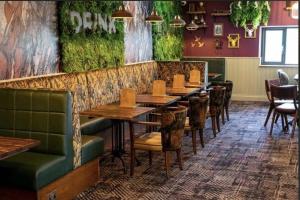 a dining room with wooden tables and green seats at 128 Hengar Manor in Bodmin