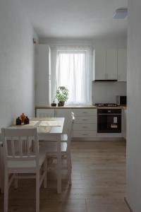 a kitchen with a white table and a white table and chairs at Solomon Apartments Ap 4 in Sângeorgiu de Mureș