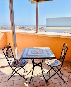Dimora La Torre في باكينو: طاولة وكرسيين على شرفة