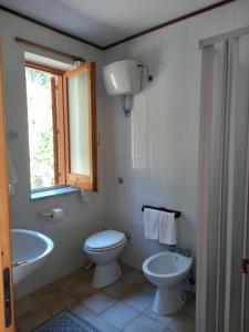 a bathroom with a toilet and a tub and a sink at Casa de rosa in Palinuro