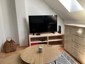a living room with a tv and a coffee table at Studio Loft in Pécs
