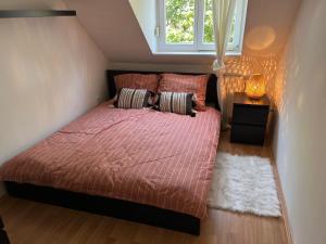 a bedroom with a bed with a red comforter and a window at Studio Loft in Pécs