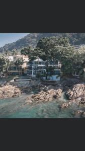a large building on the shore of a body of water at patong sunset villa Phuket in Patong Beach
