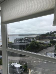 ein Fenster mit Blick auf die Straße und das Wasser in der Unterkunft Shoreline in St Ives