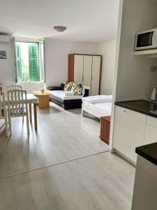 a kitchen and living room with a couch and a table at Apartments Arena in Pula