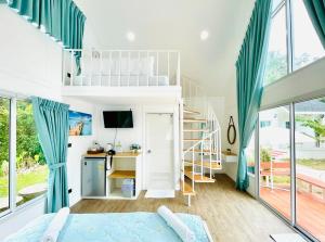 a bedroom with blue curtains and a bunk bed at Thirty Tree Garden House in Chumphon