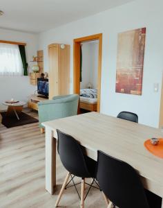 - un salon avec une table et des chaises dans l'établissement Appartement Gern, à Alpendorf