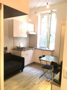 cocina y sala de estar con sofá y mesa en Petit studio bien placé jardin et parking gratuit, en Toulouse