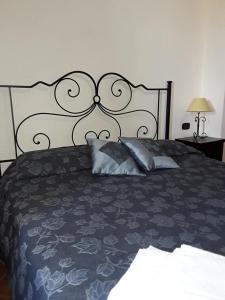 łóżko z czarno-białą narzutą i poduszkami w obiekcie Agriturismo Camemi di Paternico Ettore Piazza Armerina (EN) w mieście Piazza Armerina