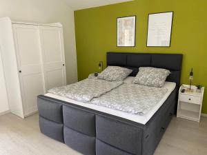 uma cama grande num quarto com uma parede verde em Ferienwohnung Burgzauber em Kastellaun