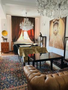a living room with a couch and a chandelier at Vila Siam - adults only holiday retreat in Slănic-Moldova
