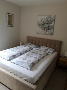a bed in a bedroom with a picture on the wall at Apartment Gorski javor in Jahorina