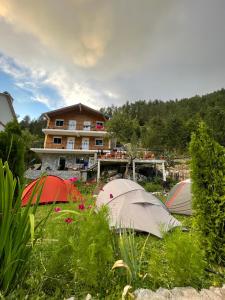 Trois tentes dans l'herbe devant une maison dans l'établissement Bujtina Brahim Selimaj, à Valbonë
