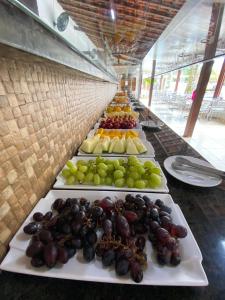 uma fila de pratos de fruta numa mesa em Pousada Acquaville em Bertioga