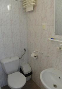 a bathroom with a white toilet and a sink at Motel Strzeszynek in Poznań