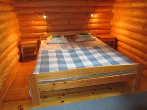 a bed in a wooden room in a cabin at Lappalaisen lomamökit Lepola in Puumala
