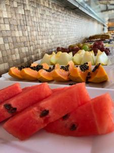 une plaque de denrées alimentaires avec pastèque et autres fruits dans l'établissement Pousada Acquaville PISCINA CLIMATIZADA, à Bertioga