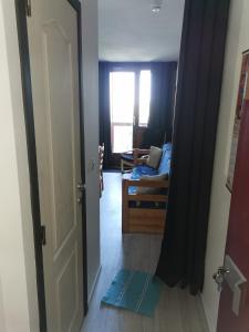 une porte ouverte sur un salon avec un canapé dans l'établissement Appartement Edelweiss Chamrousse vue sur Recoin La Croix de Chamrousse Grenoble, à Chamrousse