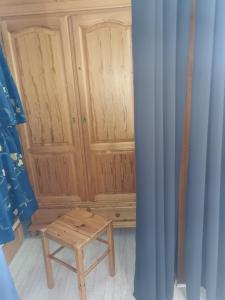 Cette chambre comprend une armoire en bois avec une table en bois. dans l'établissement Appartement Edelweiss Chamrousse vue sur Recoin La Croix de Chamrousse Grenoble, à Chamrousse
