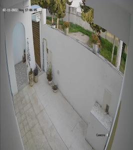 an overhead view of a white balcony with potted plants at Maison koukou in Boumhel El Bassatine