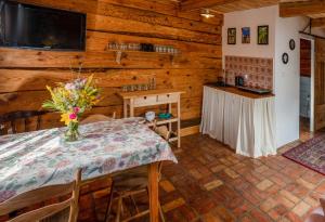 a dining room with a table with a vase of flowers on it at Alpakowo- Wolna Chata 20 in Drohiczyn