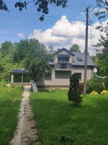 dom z drzewem przed nim w obiekcie Pensjonat Klimat Bircza w mieście Bircza