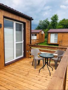 a wooden deck with a table and chairs on it at Marina Houses in Ruciane-Nida